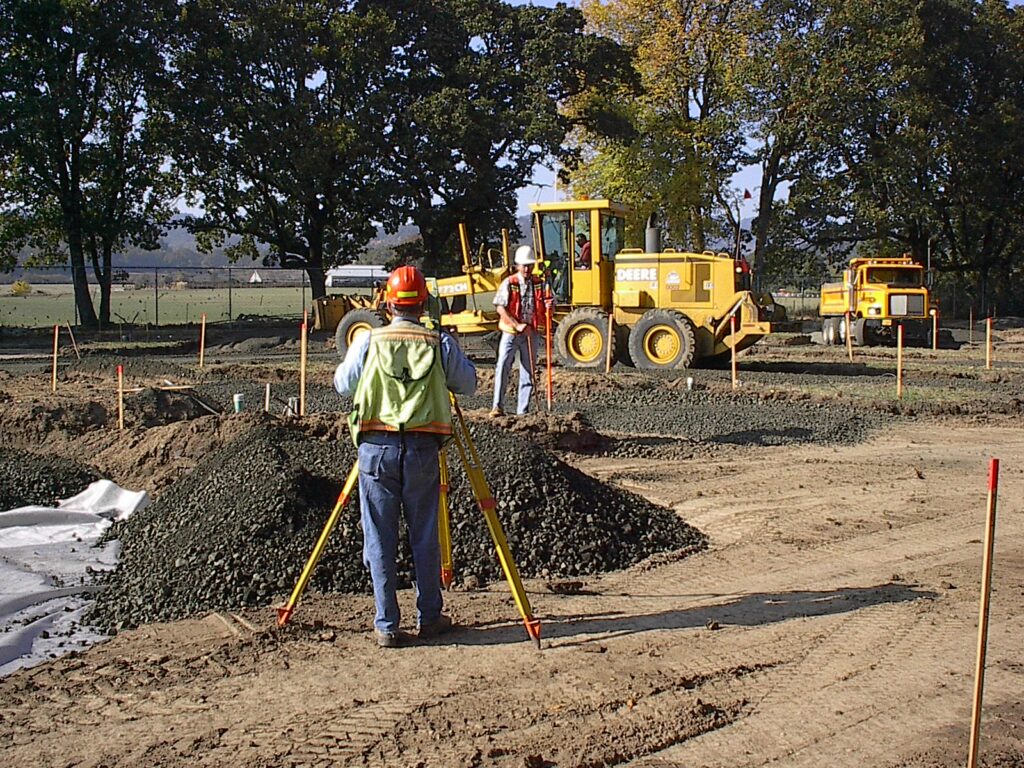 Man using survey equipment at construction site.